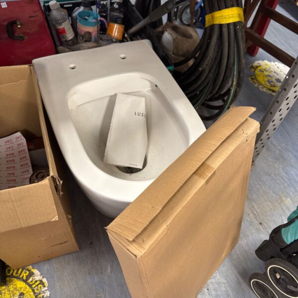 White Lusso toilet pan with seat, ready for installation.