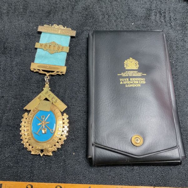 Gold Masonic Past Master jewel with blue ribbon.