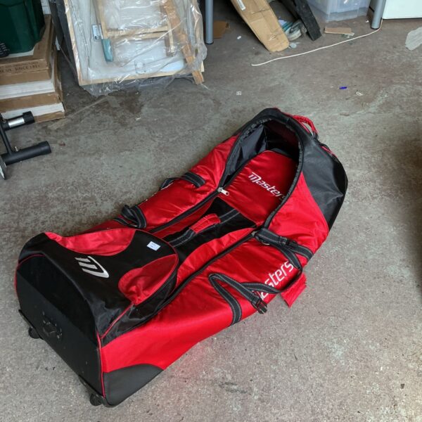 Red Masters golf travel bag with wheels for easy transport.