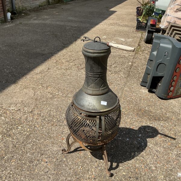 Rustic metal fire basket for outdoor patio heating.
