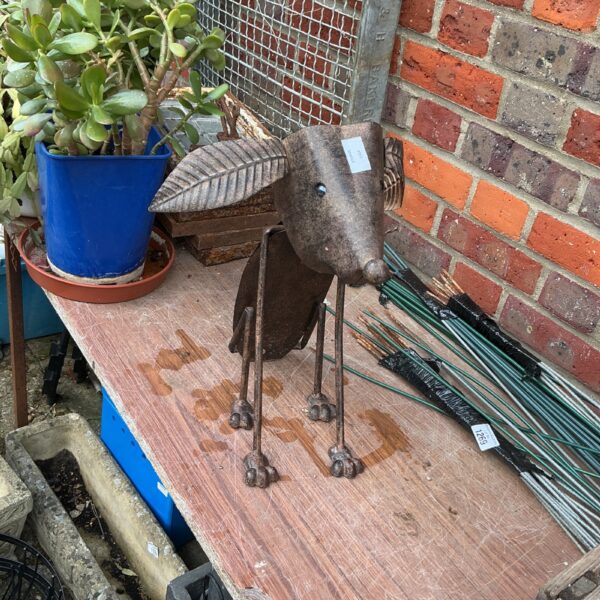 Rustic metal garden dog ornament with a nodding head.