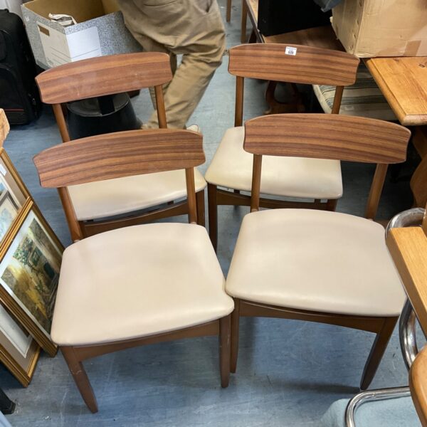Set of four mid-century modern teak dining chairs with upholstered seats.