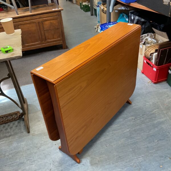 Vintage midcentury teak drop leaf table with gateleg supports.