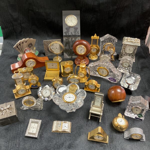 Collection of miniature quartz desk clocks on display.