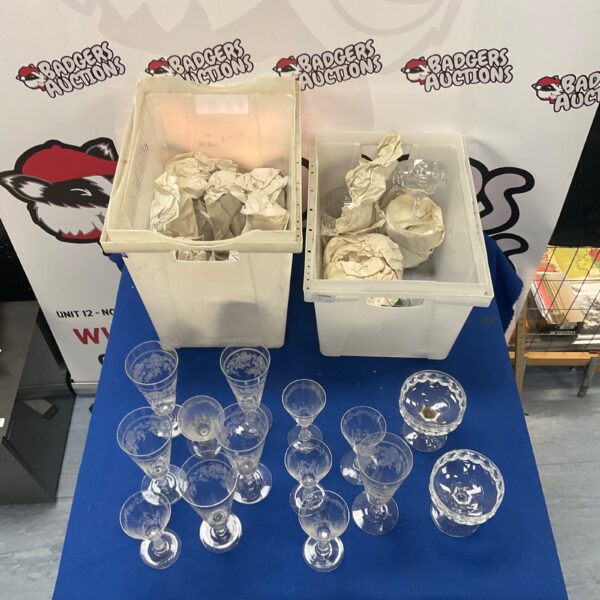 Large lot of mixed crystal glasses on a blue surface.