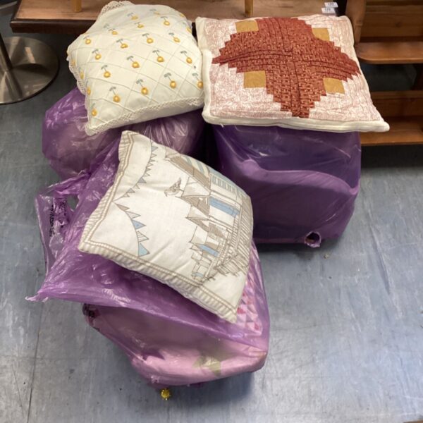 Mixed cushion lot in plastic bags, ready for auction.