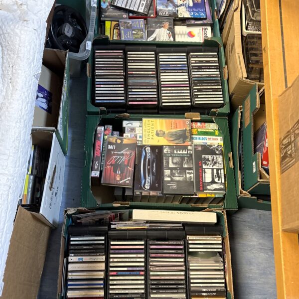 Mixed media lot of DVDs, CDs and VHS tapes in crates.