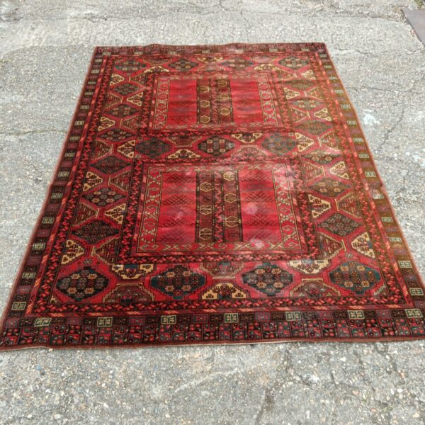 Vibrant red Mossul rug with geometric patterns and wool construction.
