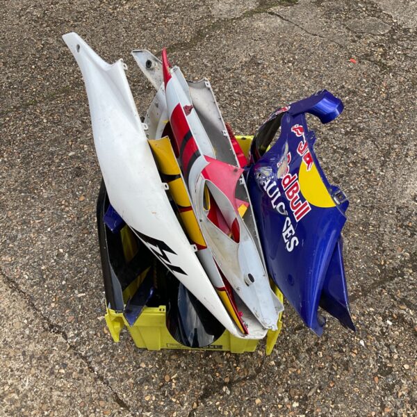 Collection of used motorcycle fairings in blue, red and white.