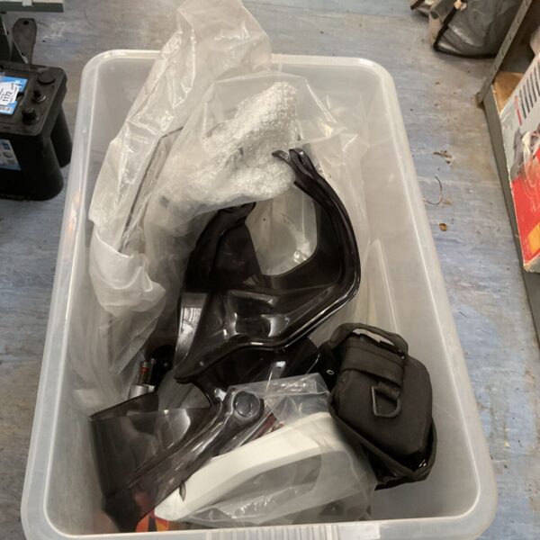 Motorcycle front screens and parts in a storage container.