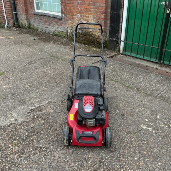 Red Mountfield Stiga petrol lawnmower in a garden setting.