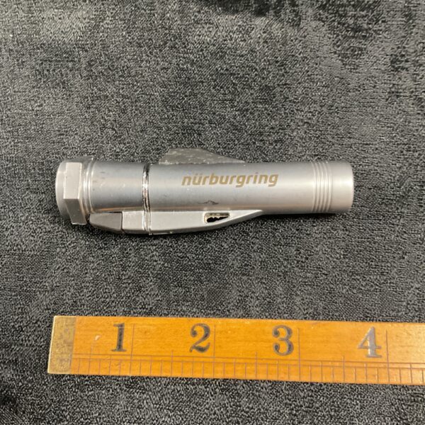 Vintage Nurburgring gas lighter and flashlight tool.
