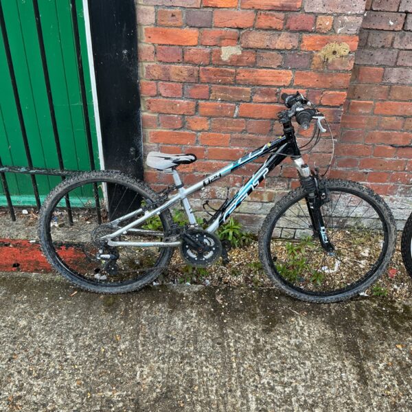 Silver and black O24 boys mountain bike with front suspension.