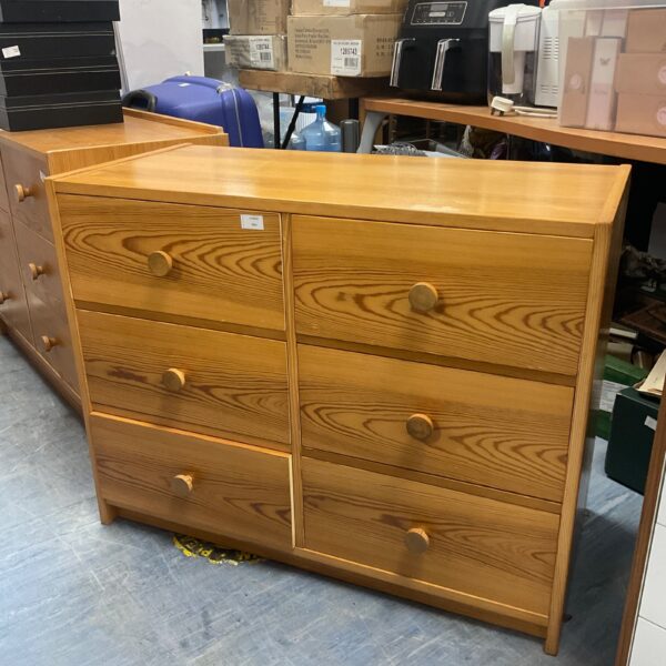 Vintage oak chest of drawers with multiple drawers for bedroom storage.