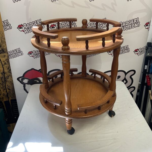 Vintage oak serving trolley with two tiers and casters.