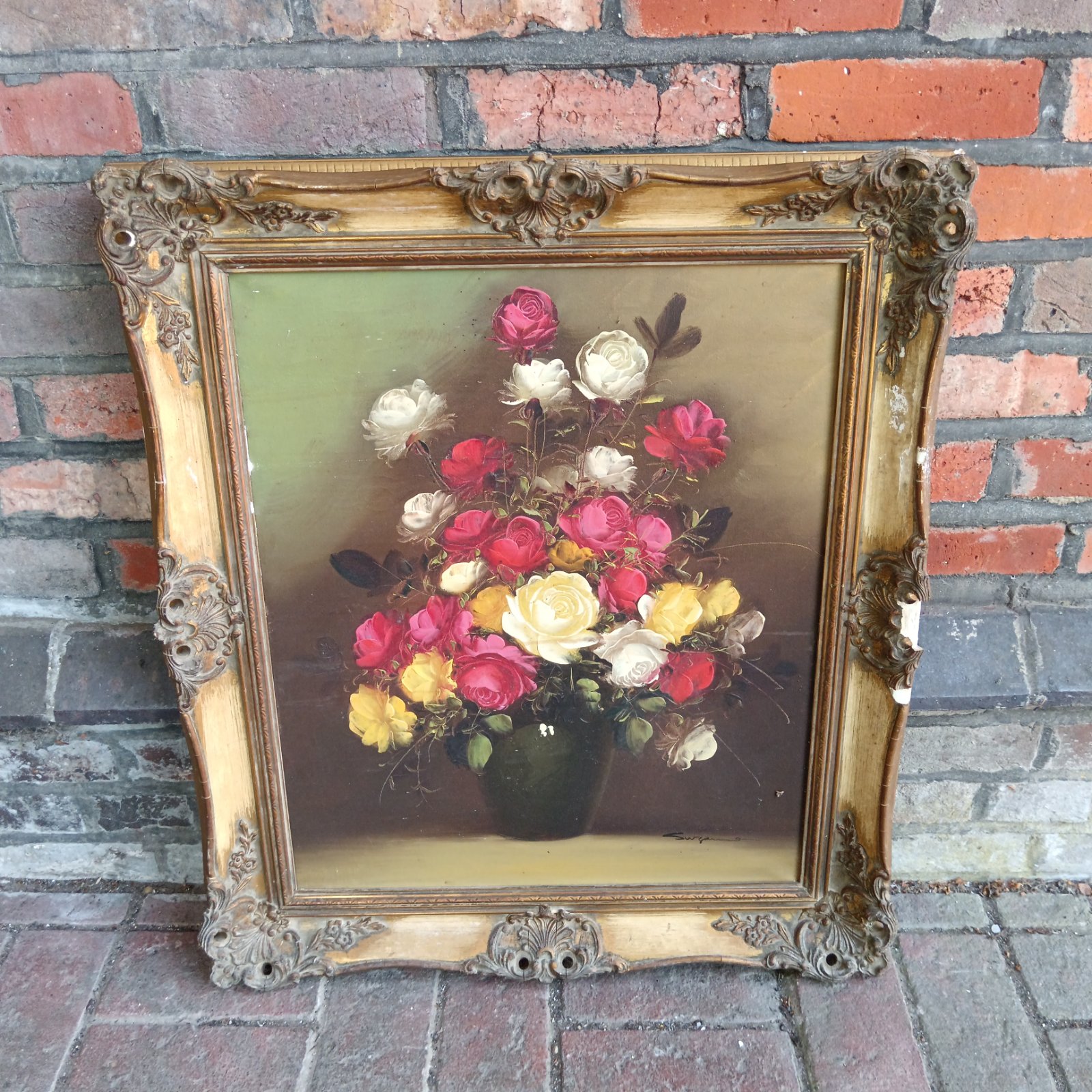 Signed oil painting of colourful flowers in a gilt frame.