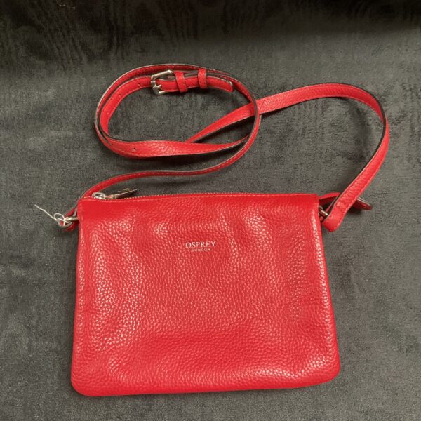 Red leather Osprey London shoulder bag with adjustable strap.