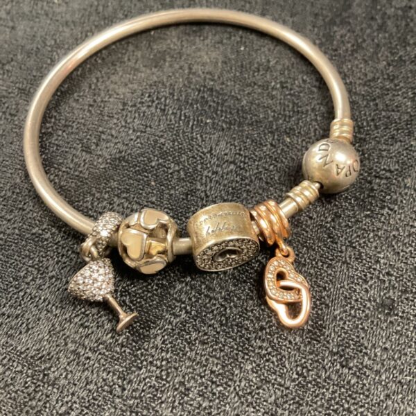 Silver Pandora charm bracelet with four decorative charms.