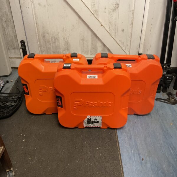 Three orange Paslode cordless nailer cases for tool storage.