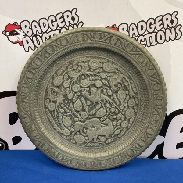 Vintage Persian charger plate with detailed hunt scene embossing.