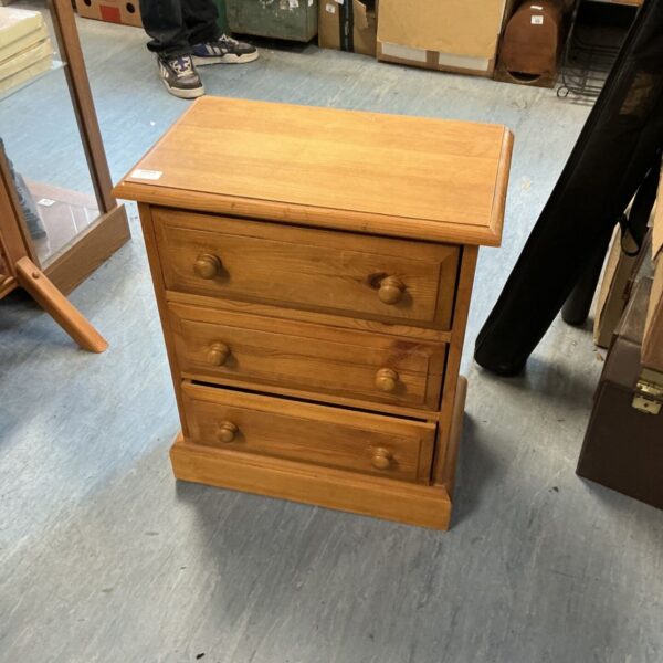 Small pine three drawer cabinet with wooden knobs.