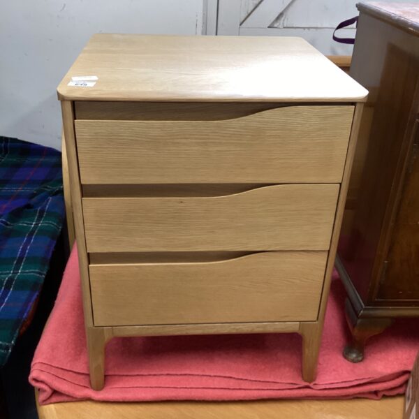 Vintage pine three-drawer cabinet for bedroom storage.