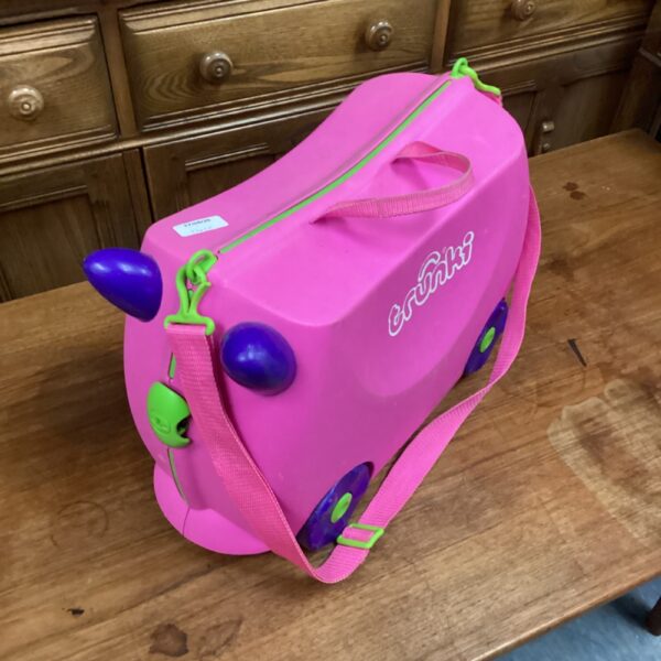 Pink Trunki kids ride on suitcase with handle.