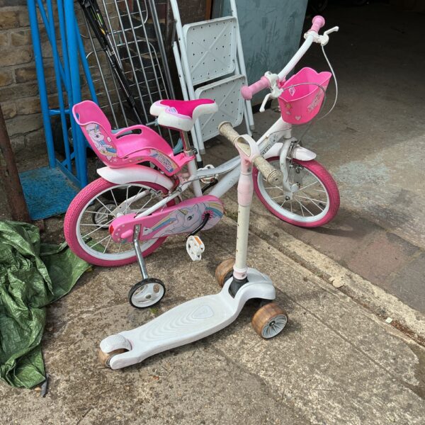 Pink unicorn bicycle and three-wheeled scooter for children.