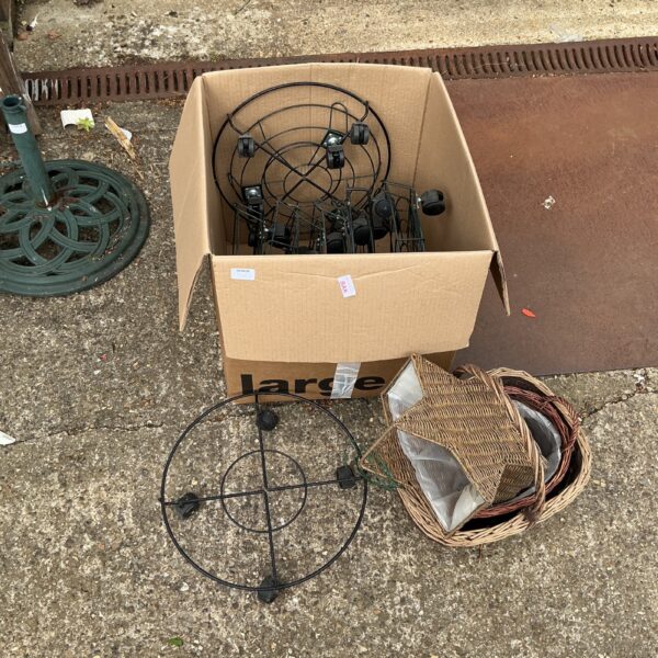 Lot of metal plant pot holders and wicker baskets for garden display.