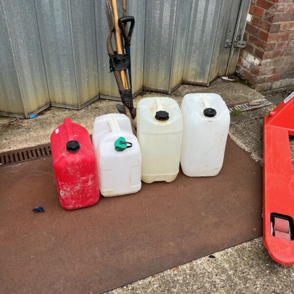 Lot of four used plastic water containers for storage.