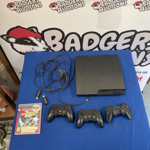PlayStation 3 console with remotes and game case.