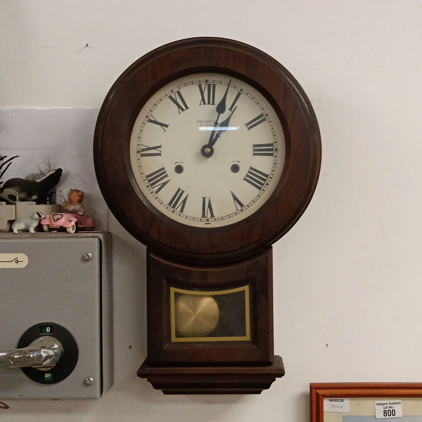 Vintage President wall clock with Roman numerals and wooden case.