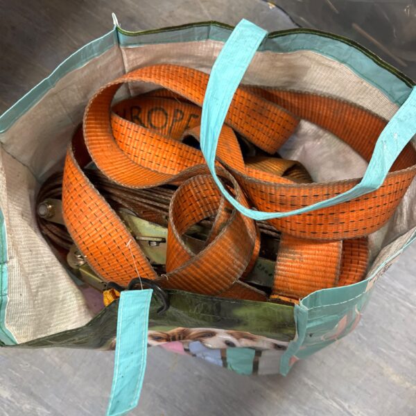 Orange ratchet straps in a bag, heavy duty cargo securing straps.