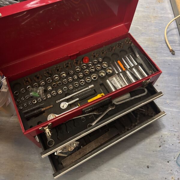 Red mechanic's toolbox open with socket set inside.