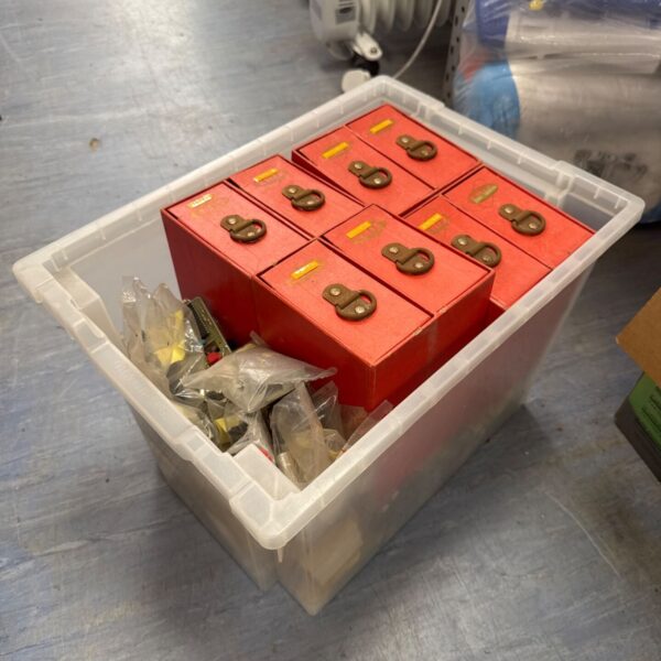 Red plastic storage drawers and mixed hardware in a plastic container.