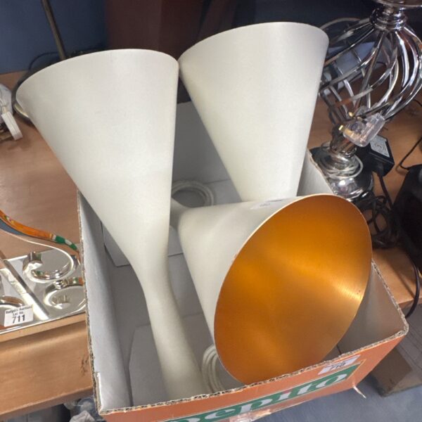 Three white and copper conical ceiling lights in a retro style.