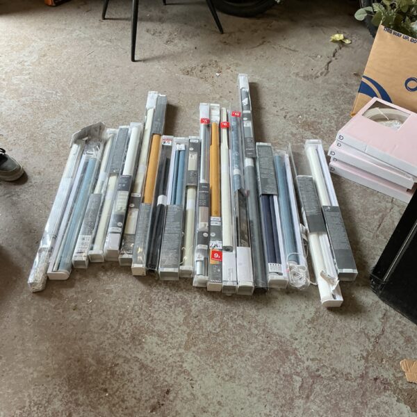 Mixed size lot of new roller blinds for home window coverings.