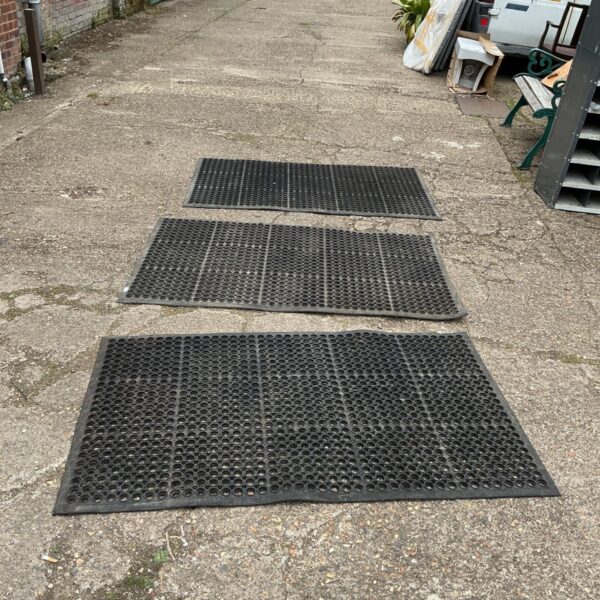 Lot of three rubber non-slip mats for workshop safety.