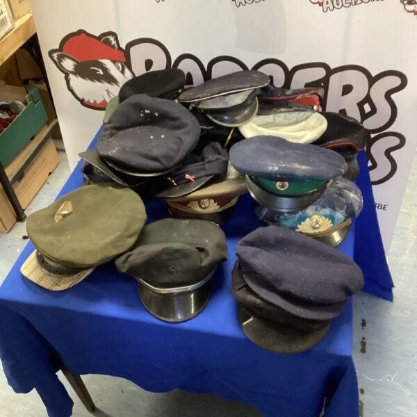 Lot of vintage Russian military hats including Ushankas and peaked caps.