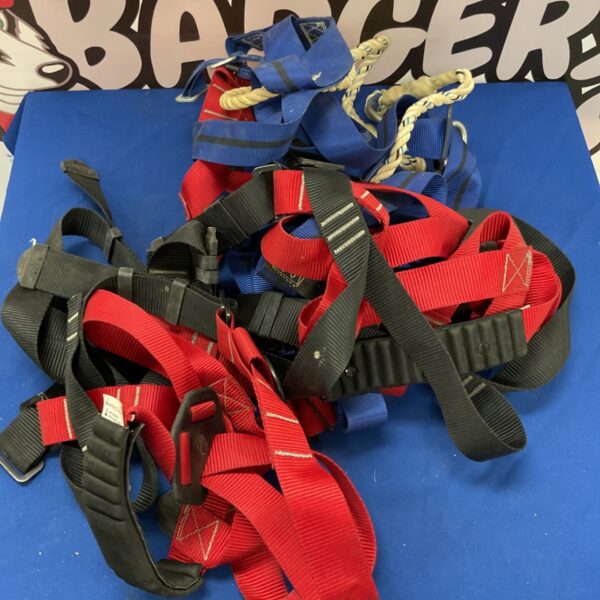 Collection of used safety harnesses for fall protection and climbing.