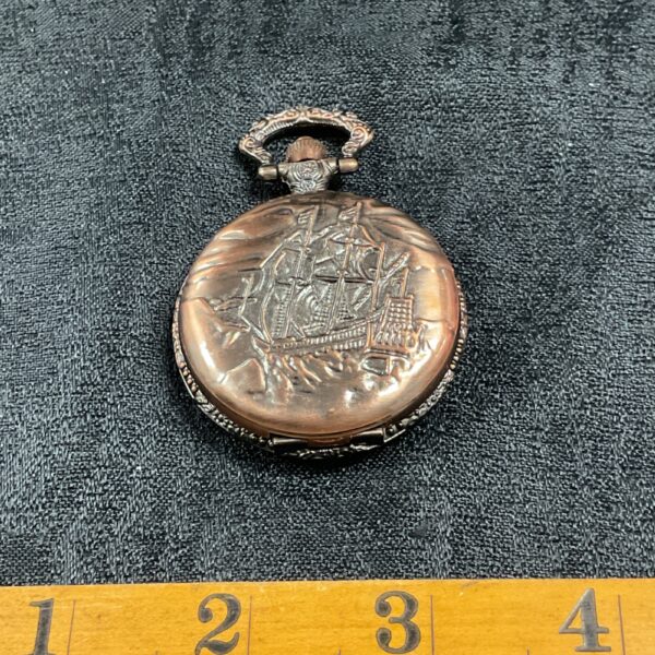 Bronze sailing ship pocket watch with detailed embossed design.