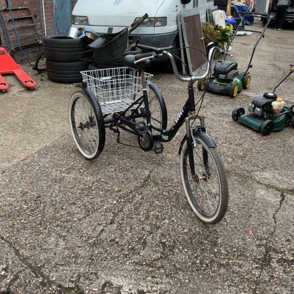 Side view of a vintage Scout tricycle with a rear basket.