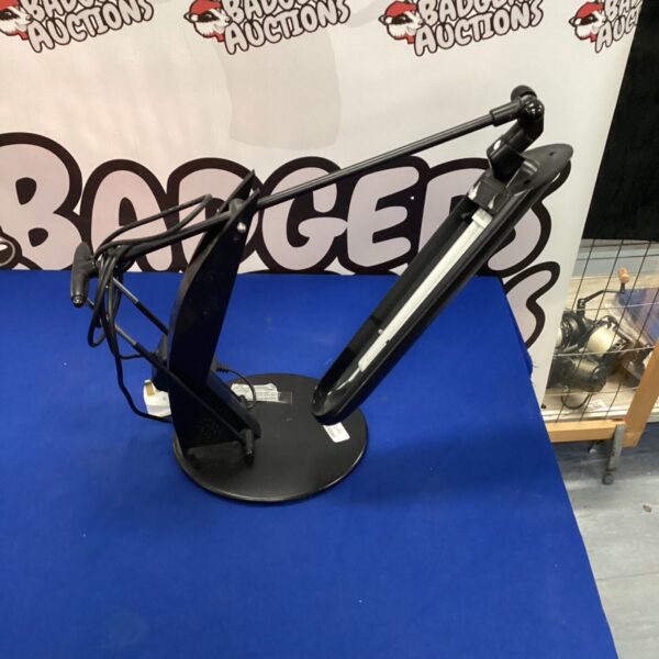 Vintage searchlight desk lamp with adjustable arm and conical shade.