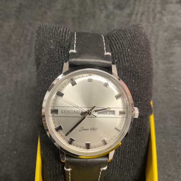 Vintage Sekonda quartz wristwatch with silver dial and leather strap.