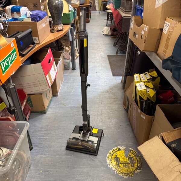 Shark IZ400UK cordless vacuum cleaner in a cluttered room.
