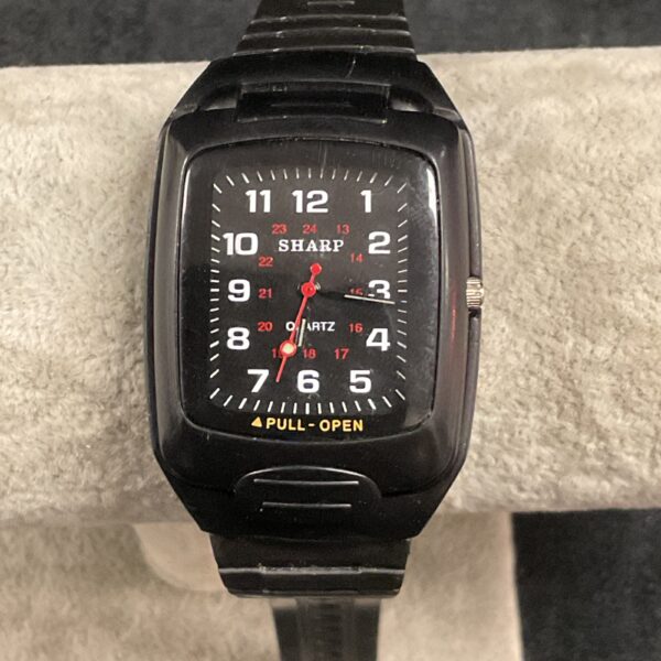 Front view of vintage Sharp quartz calculator watch with red display.