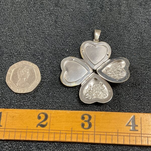 Vintage silver clover pendant with heart compartments.