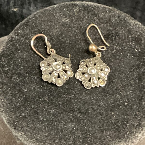 Vintage silver drop earrings with a floral design.