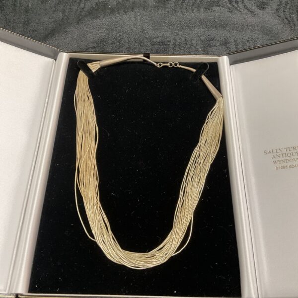 Silver multi strand necklace displayed in presentation box.