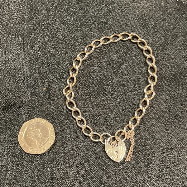 Close-up of a vintage silver padlock bracelet with a secure clasp.